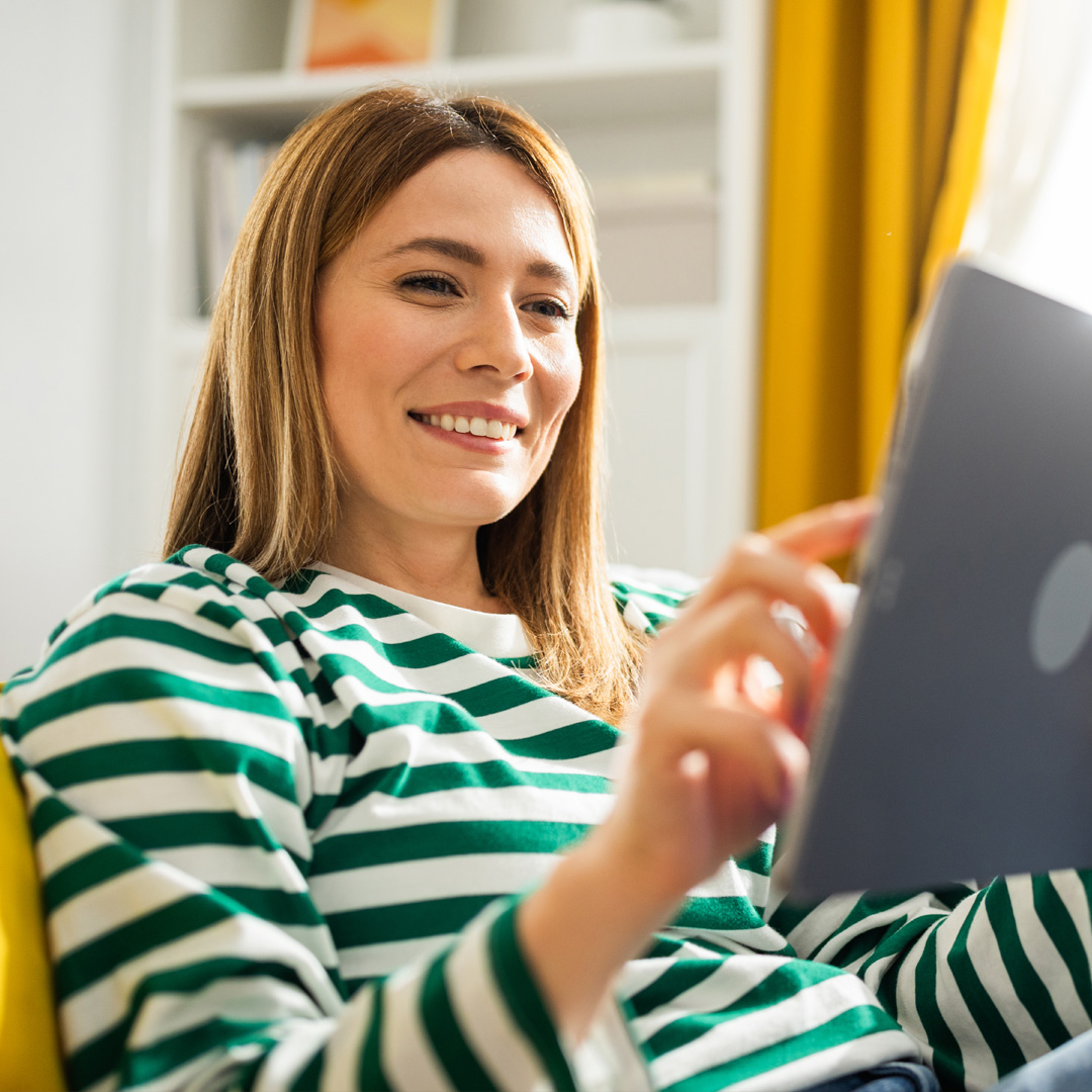 woman in stripped shirt browsing on tablet